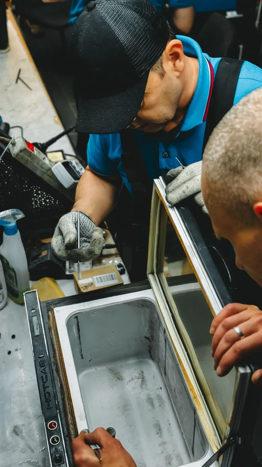 Technician opening an appliance panel to diagnose a fault