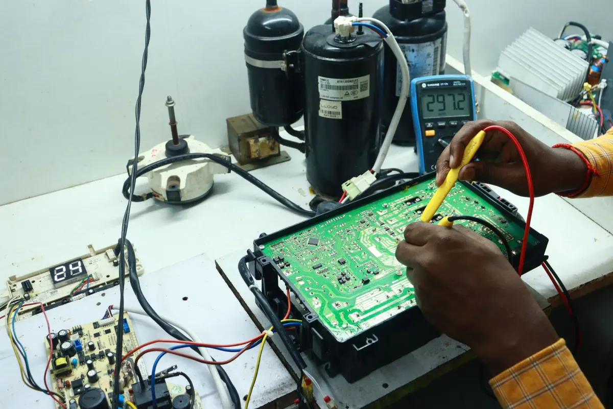 Technician testing an appliance control board with a multimeter